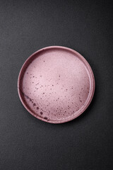 Empty round ceramic plate on a dark textured background