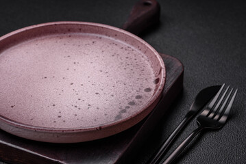 Empty round ceramic plate on a dark textured background