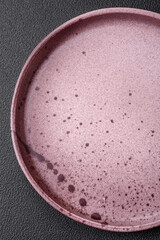 Empty round ceramic plate on a dark textured background