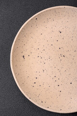 Empty round ceramic plate on a dark textured background