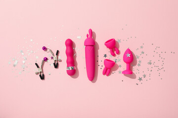 Sex toy with Christmas decor on a pink background.