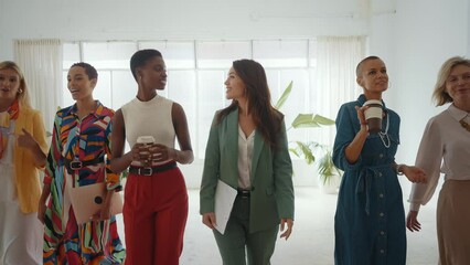 Cinematic footage of a multiethnic group of women managing new projects in a start up business. Female colleagues working as a team in the office wearing elegant colored diverse outfits - Powered by Adobe