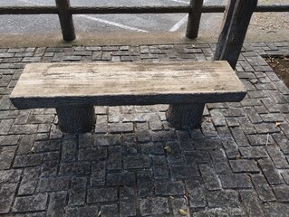 石畳のエリアに木目調の石の椅子が設置されている。