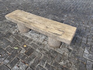 石畳のエリアに木目調の石の椅子が設置されている。