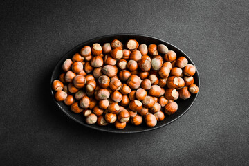 Nuts background. Hazelnuts in a black oval bowl. Healthy Eating. Close up.