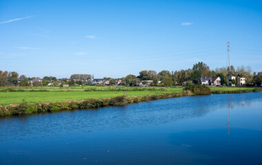 Obraz premium Houses and nature reflecting in the water of the river Dender, Ninove, Flemish Region, Belgium, October