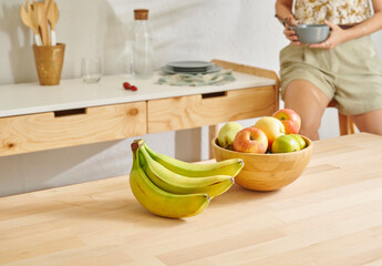 Fototapeta premium Close up fruit basket on the wooden table, kitchen, banana, apple and pear. Woman background style.