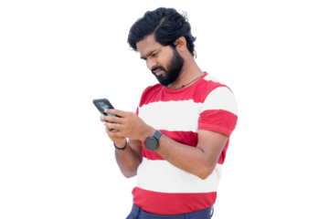 a man with a beard is looking at his cell phone while wearing a red and white shirt and blue pants