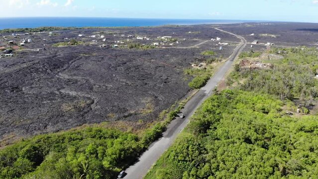 Road into Kalapana with houses built on lava and wild hawaiian jungle