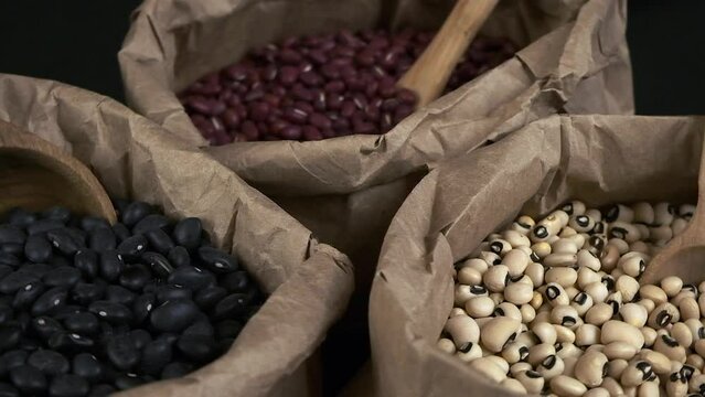 Narrow focus macro closeup: Nutritious dry beans in paper bags rotate