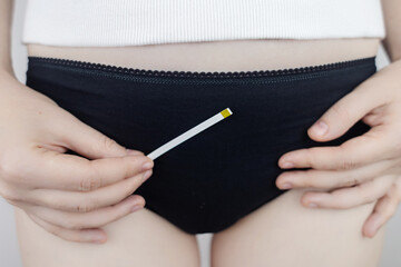 Bacterial Vaginosis. Vaginal pH. Girl shows sticks for measuring acid-base balance of genital...