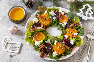 Christmas appetizer. Christmas wreath salad with beetroot, tangerines, feta cheese and pecans on...