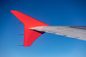 Airplane wing against blue sky. View from airplane window. - 661410311