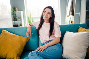 Photo of lovely positive lady sitting comfy couch toothy smile contemplate imagine modern apartment...