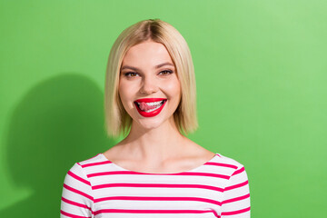 Photo of good mood girlish woman with bob hairstyle dressed striped stylish shirt licking teeth...