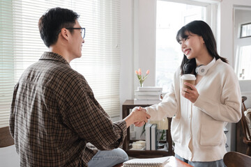 Young students sit in the library studying, sharing knowledge and holding hands. Educational concept
