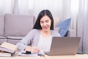 Asian happy female working at home calculate bookkeeping for tax declarations using modern technology laptop, well-organized planning financial payment for housing loan, women working paperwork bills