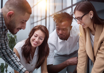 Group of young business people working together while standing in creative office