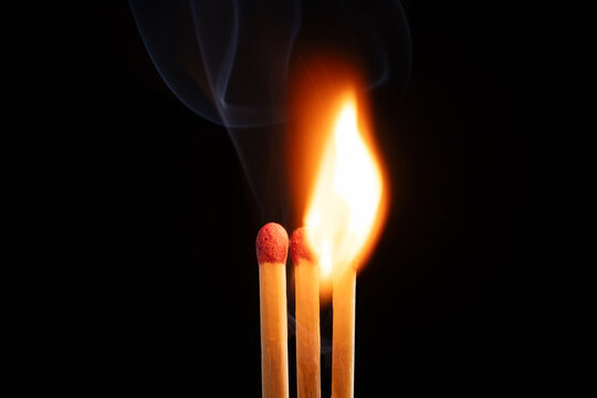 Wooden matches with fire on a black background