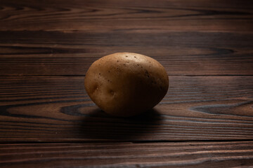 Fototapeta na wymiar Fresh harvested potato on a rough wooden surface