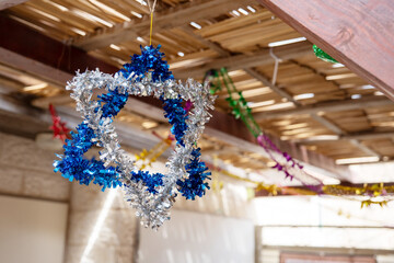 Star of David made from blue and silver tinsel hang in a sukkah on Sukkot holiday