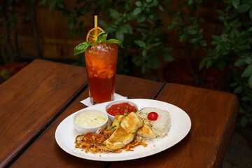 Grilled chicken breast with rice, fried onion, salsa and avocado sauce with a lemonade