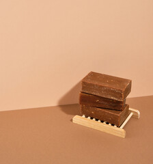 Three large pieces of natural organic soap on a wooden soap dish. Copy space for text.