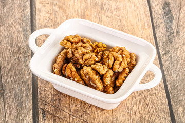 Cracked unshelled walnut in the bowl