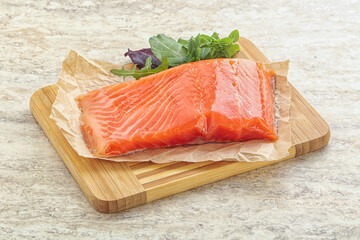 Raw salmon fillet over board