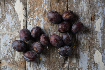 Ripe plums on an old wooden background, horizontal format, top view