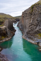 Basalt columns in Studlagil canyon in Iceland. Lava flows in Northeast Iceland, Bru river in Jokudalur Valley. Travel beauty of nature concept and background.