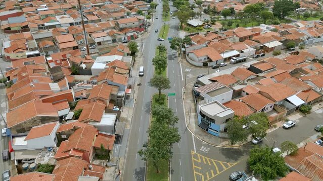 Vista a&eacute;rea de bairro residencial na cidade de Paul&iacute;nia com casas de telhado laranja e muitas &aacute;rvores e vegeta&ccedil;&atilde;o ao redor. Brasil, 2023.