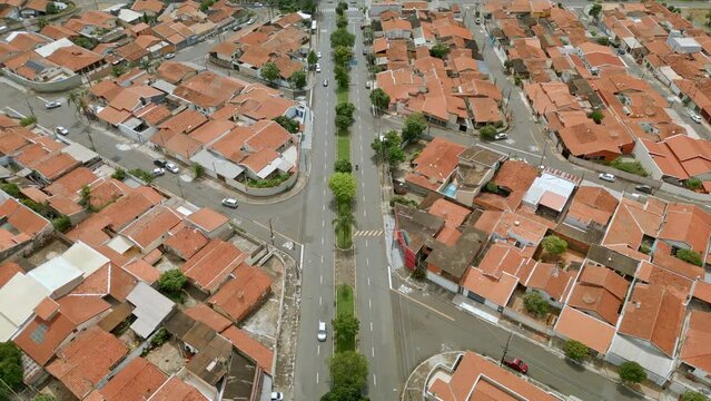 Vista a&eacute;rea de bairro residencial na cidade de Paul&iacute;nia com casas de telhado laranja e muitas &aacute;rvores e vegeta&ccedil;&atilde;o ao redor. Brasil, 2023.