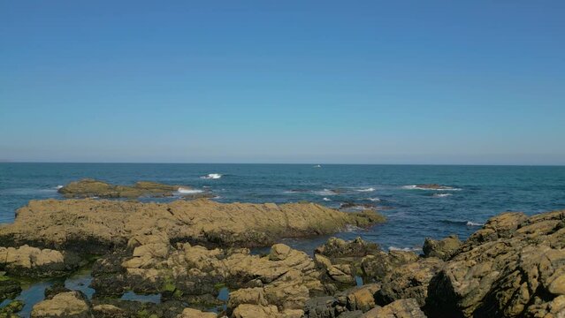Ocean Waves Crashing On The Rocky Outcrops And Coastline In Caion, Spain. - aerial pullback