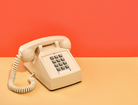 A composition of old vintage beige phone with gray buttons on table. Copy space for text.