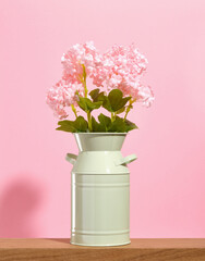 Bouquet of nice flowers in a green vase on a pink background. Ecology concept. Flowers in greenhouse.