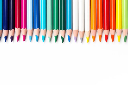 Chaotically placed wooden color pencils on a white background, top view