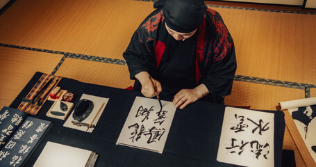 Top Down View of a Japanese Male Calligraphy Artist Drawing Aesthetic Spiritual Symbols in Kanji...