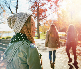 Teenage girl in nature with friends, walk in park with autumn and sunshine, wellness with...