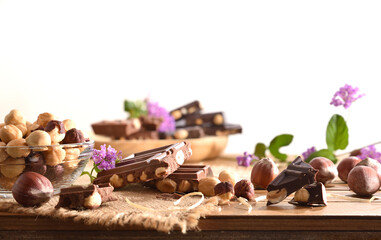 Detail of chocolate with hazelnuts on wooden table isolated white