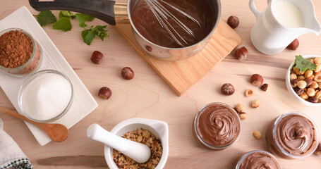 Table with ingredients in bowls to make homemade hazelnut cream - obrazy, fototapety, plakaty