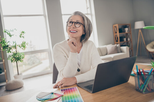 Photo of good mood dreamy senior lady architect dressed white cardigan thinking new design colors indoors house room