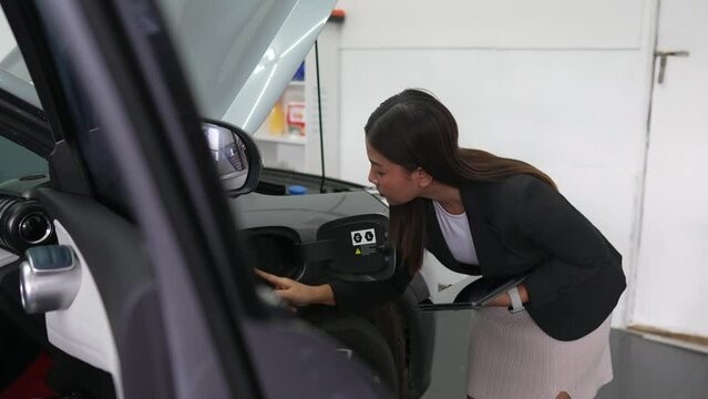 Female officer inspects electric car, electric car insurance concept