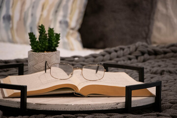 Reading Glasses Sitting on an Open Book on a Bed