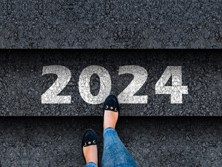 happy new year 2024. Woman legs in sneakers standing next to stairs with number 2024

