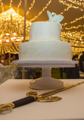 Fondant wedding cake over table with sword at banquet hall
