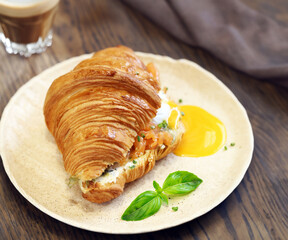 traditional croissant with salmon and egg for breakfast