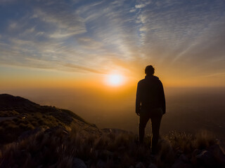 Silhouette of woman, in majestic sunset over mountain.