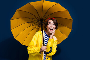 Photo of cute girl waiting her boyfriend on new car rainy weather protect herself parasol look curious isolated over blue color background © deagreez
