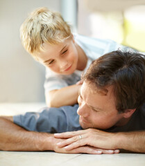 Smile, relax and dad with son on floor, cute bonding together with care and love in home. Fun, father and child lying on ground in house with happy relationship, trust and support with man and boy. - obrazy, fototapety, plakaty